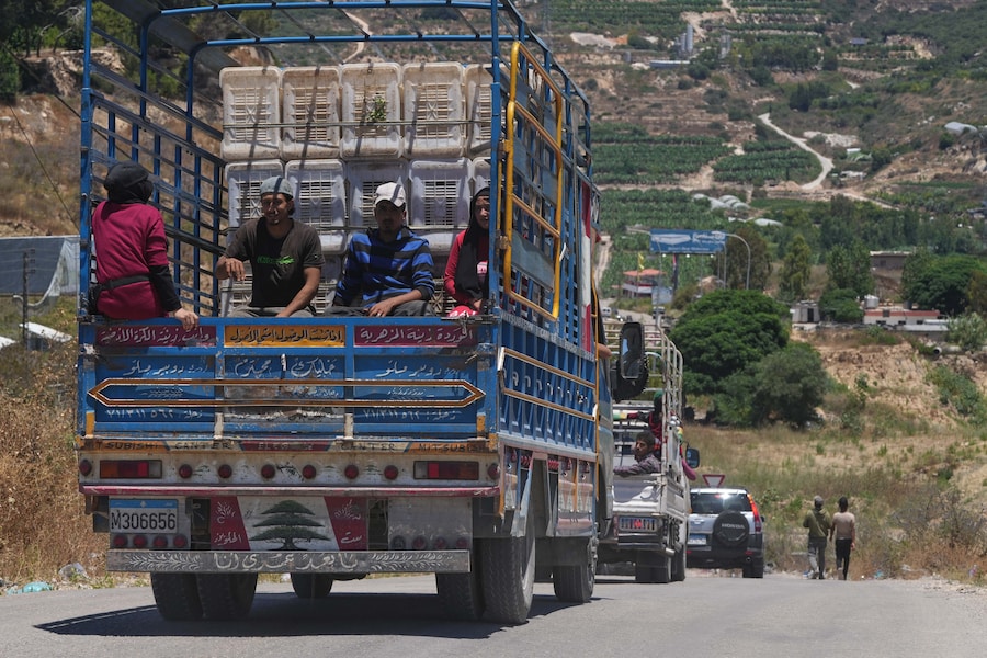Nel villaggio di Borj Rahhal, in Libano, alcune persone viaggiano sul cassone di un camion carico di effetti personali mentre gli abitanti abbandonano il Libano meridionale a seguito dei bombardamenti israeliani. (AP Photo/Hassan Ammar/Associated Press/LaPresse/APN)