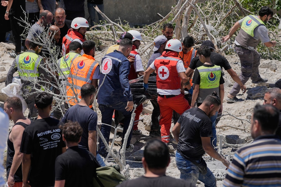 I soccorritori trasportano una vittima rinvenuta sotto le macerie di un edificio distrutto da un attacco aereo israeliano nel villaggio di Qannarit, nel sud del Libano. (AP Photo/Mohammed Zaatari/Associated Press/LaPresse/APN)