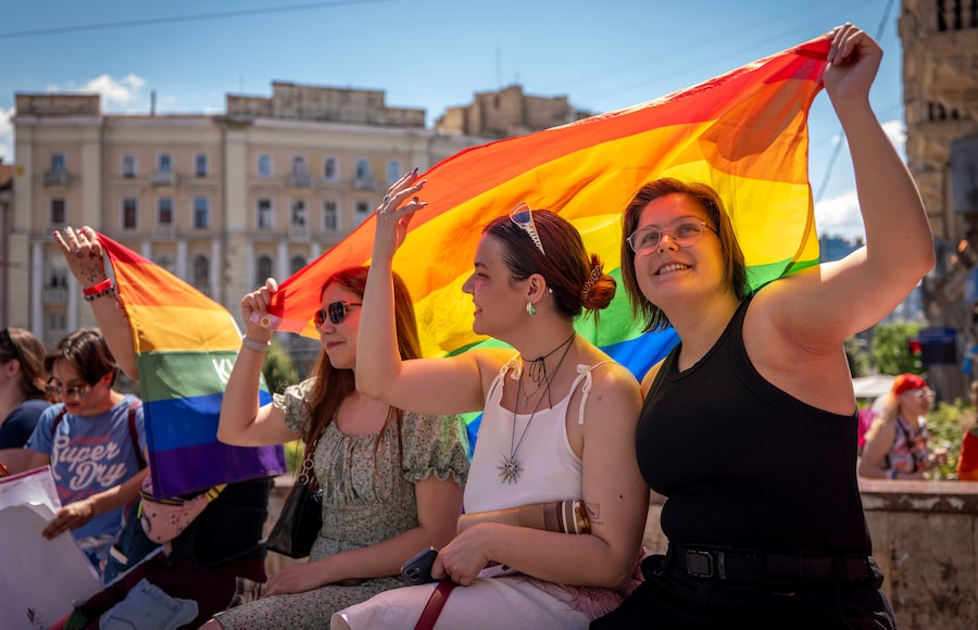 I partecipanti sventolano una grande bandiera arcobaleno durante la marcia annuale per l'uguaglianza “KyivPride” a Kiev, in Ucraina, domenica 21 giugno 2026. (APN)