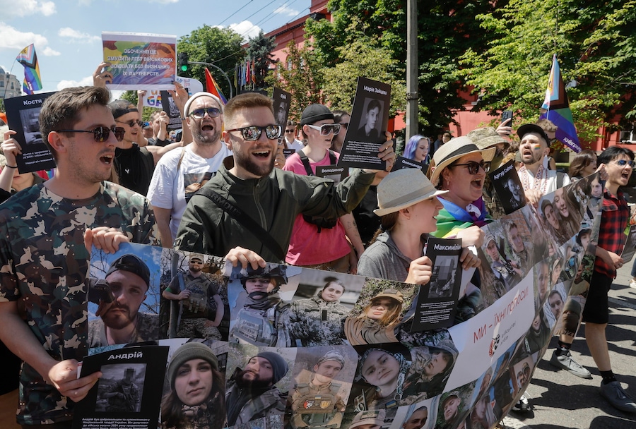 Militari ucraini, membri della comunità LGBTIQ+ e loro sostenitori espongono uno striscione con i ritratti dei soldati LGBTQ+ caduti in guerra, durante la marcia annuale del KyivPride, a Kiev, in Ucraina, il 21 giugno 2026. (EPA)