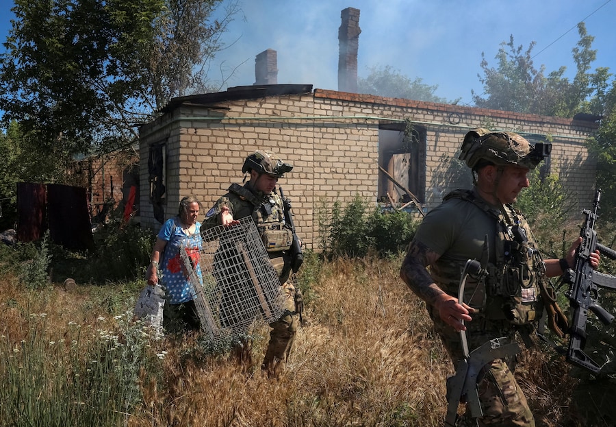 I membri dell'unità di evacuazione della polizia "White Angels" assistono un residente durante l'evacuazione dalla città di Druzhkivka, situata in prima linea, nel contesto dell'attacco russo all'Ucraina, nella regione di Donetsk. (REUTERS/Anatolii Stepanov)