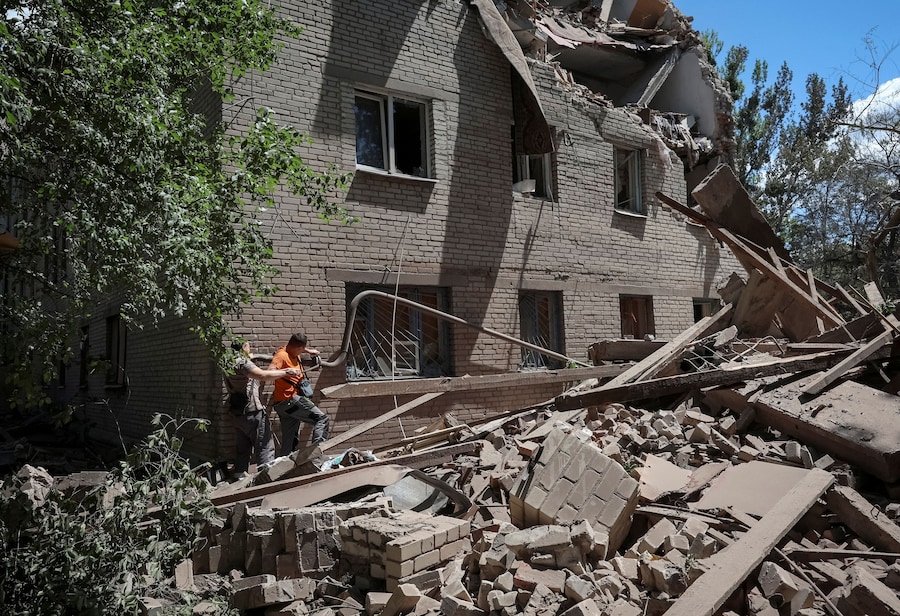 I residenti ispezionano un condominio danneggiato da un attacco militare russo, nel contesto dell'offensiva russa contro l'Ucraina, nella città di Sloviansk, in prima linea nella regione di Donetsk. (REUTERS/Anatolii Stepanov)