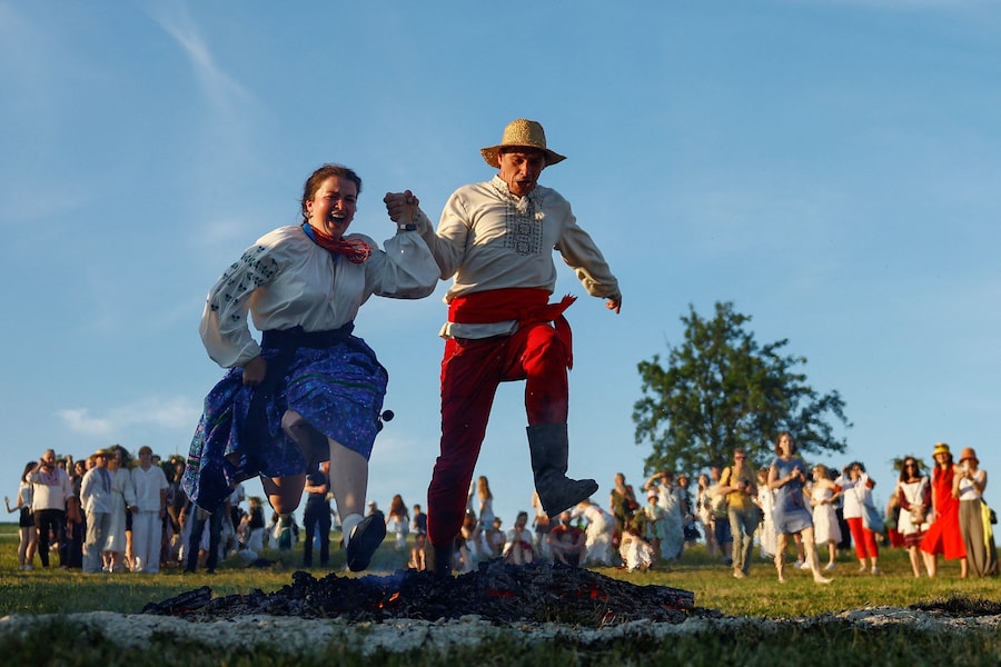 Alcune persone saltano sopra un falò durante i festeggiamenti per la festa di Ivana Kupala, un’antica tradizione che affonda le sue radici nell’epoca pagana, mentre la Russia continua l’attacco contro l’Ucraina, presso il Museo Nazionale di Architettura Popolare e Vita Quotidiana dell’Ucraina, a Kiev. (REUTERS/Valentyn Ogirenko)