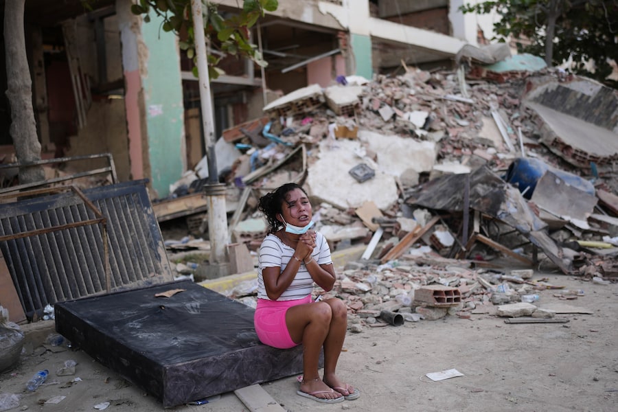 Una donna piange accanto a edifici danneggiati a La Guaira, in Venezuela (APN)