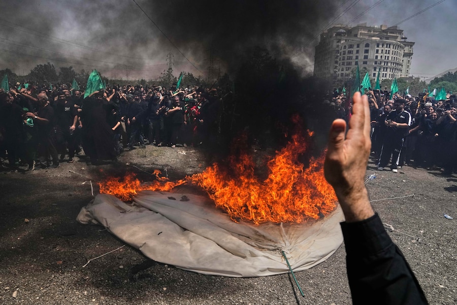 Alcune persone piangono mentre una tenda viene data alle fiamme a Teheran, in Iran, durante la rievocazione della battaglia di Kerbala (avvenuta nel 680 d.C. nell’odierno Iraq), nella quale l’Imam Hussein — nipote del profeta Maometto e una delle figure sante più venerate dell’Islam sciita — fu ucciso insieme alla sua famiglia e ai suoi compagni dopo essersi rifiutato di giurare fedeltà al califfato omayyade (APN)