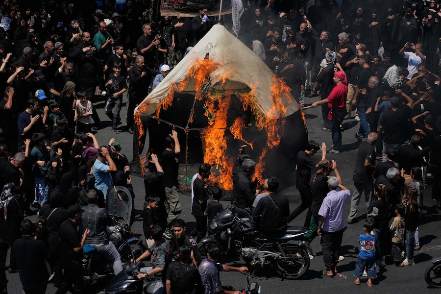 Persone in lutto attorno a una tenda data alle fiamme durante la rievocazione della battaglia di Kerbala (avvenuta nel 680 d.C. nell’odierno Iraq). Teheran, Iran (APN)