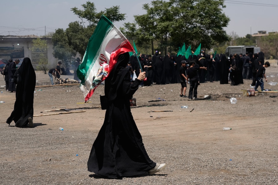 Una donna regge una bandiera iraniana a Teheran, in Iran, mentre partecipa a una cerimonia che rievoca la battaglia di Kerbala del 680 d.C. (APN)