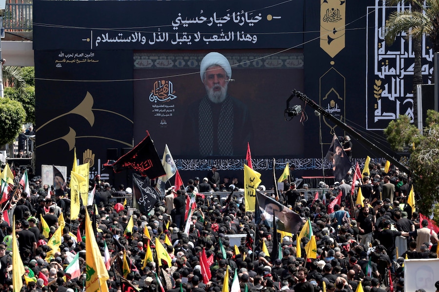 I sostenitori di Hezbollah ascoltano il discorso del leader dell’organizzazione Naim Qassem, trasmesso su un maxischermo durante una processione in occasione della Giornata dell’Ashura nel sud di Beirut, in Libano, il 26 giugno 2026. I musulmani sciiti di tutto il mondo osservano il mese sacro di Muharram, il primo mese del calendario islamico, che culmina con la commemorazione dell’Ashura il decimo giorno, in ricordo del martirio dell’Imam Hussain, nipote del Profeta Maometto, ucciso nella battaglia di Karbala. (EPA)