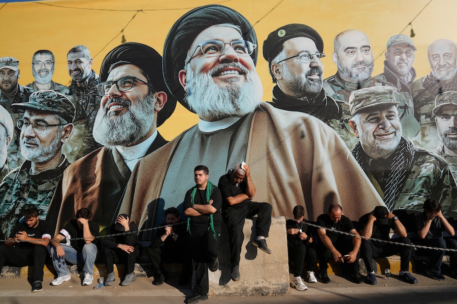 I sostenitori di Hezbollah sono seduti davanti a un cartellone gigante che raffigura i due defunti leader dell’organizzazione, Sayyed Hassan Nasrallah e Hashem Safieddine (al centro), insieme ad altri comandanti di Hezbollah caduti in battaglia, mentre ascoltano il racconto della morte dell’Imam Hussein durante la festività sacra dell’Ashura a Dahiyeh, nella periferia sud di Beirut, in Libano, venerdì 26 giugno 2026. (APN)