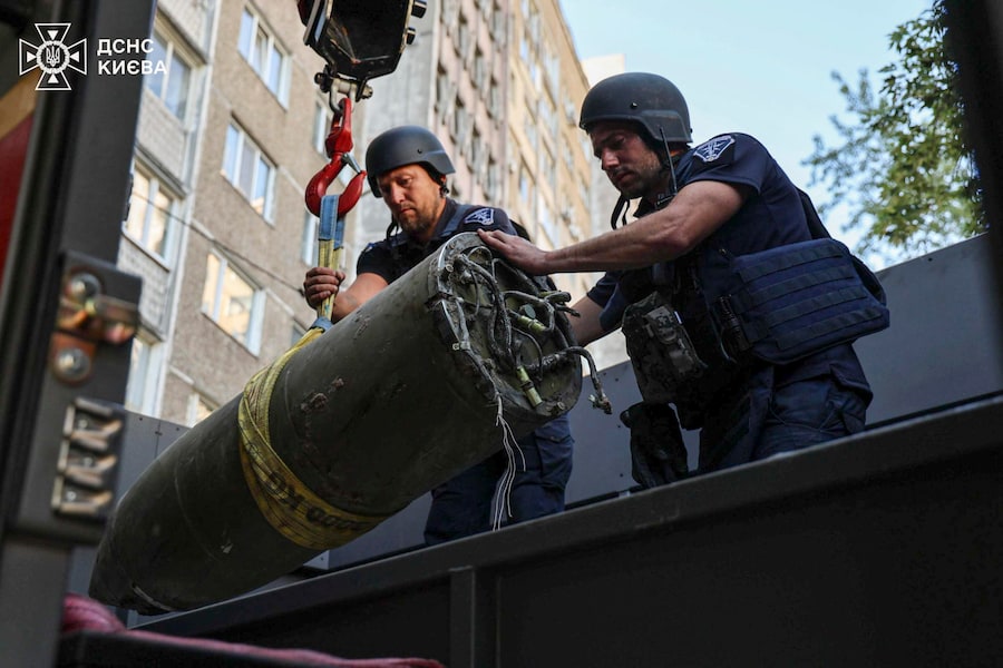 Foto diffusa dal Servizio statale per le emergenze dell’Ucraina (SES) che mostra artificieri ucraini intenti a rimuovere i detriti di un missile russo abbattuto, nel luogo in cui è precipitato vicino a un grattacielo residenziale a Kiev (EPA)