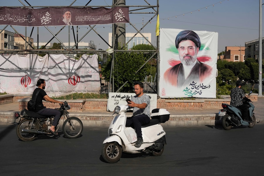Lunedì 29 giugno 2026, nel centro di Teheran, in Iran, alcune moto sfrecciano davanti a uno striscione che raffigura il ritratto della Guida Suprema iraniana, l’Ayatollah Mojtaba Khamenei. (APN)