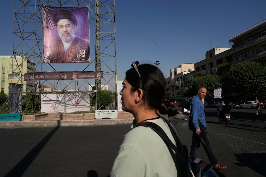 Alcuni passanti passano davanti a uno striscione che raffigura il ritratto della Guida Suprema iraniana, l’Ayatollah Mojtaba Khamenei. (APN)