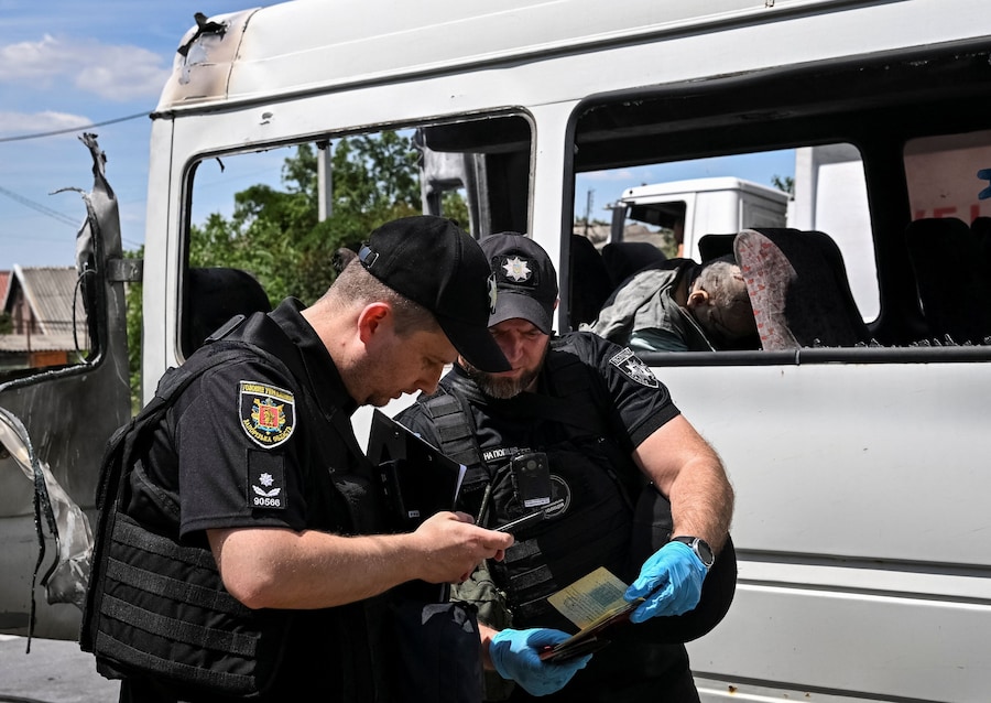 Agenti di polizia al lavoro nei pressi di un minibus colpito da un drone russo, nel contesto dell'attacco della Russia all'Ucraina, a Zaporizhzhia. (REUTERS)