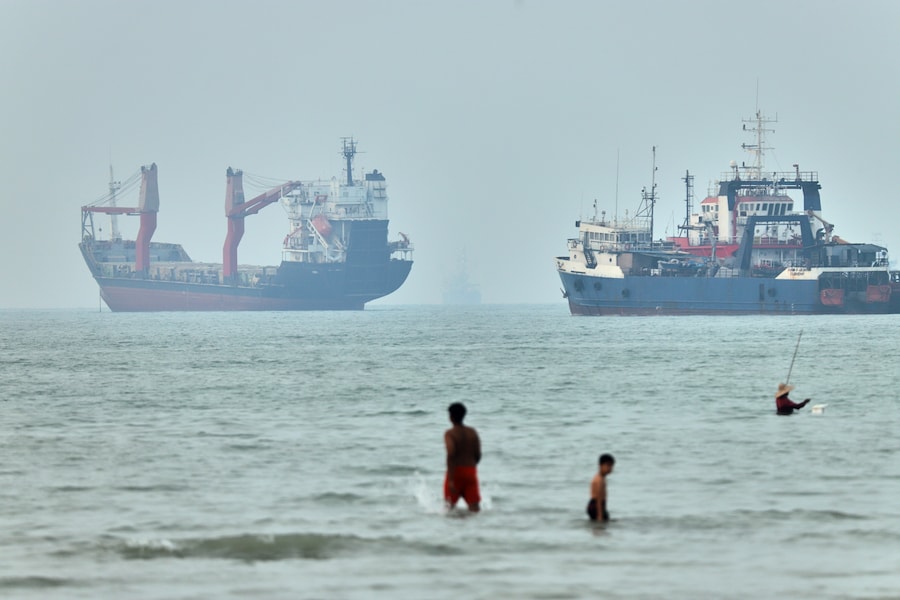Alcuni bambini giocano in acqua con le navi sullo sfondo nello Stretto di Hormuz al largo di Bandar Abbas, in Iran. (APN)
