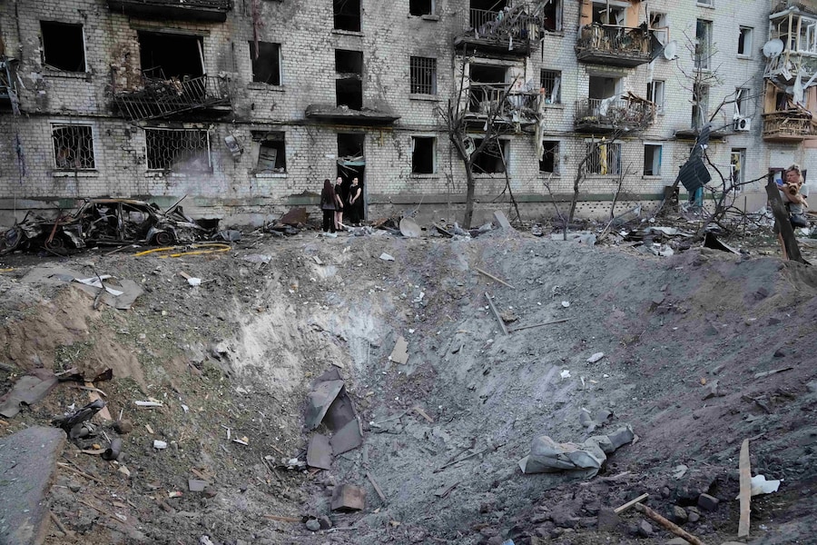 La gente osserva il luogo in cui un missile russo ha colpito un edificio residenziale a Kiev, in Ucraina. (APN)