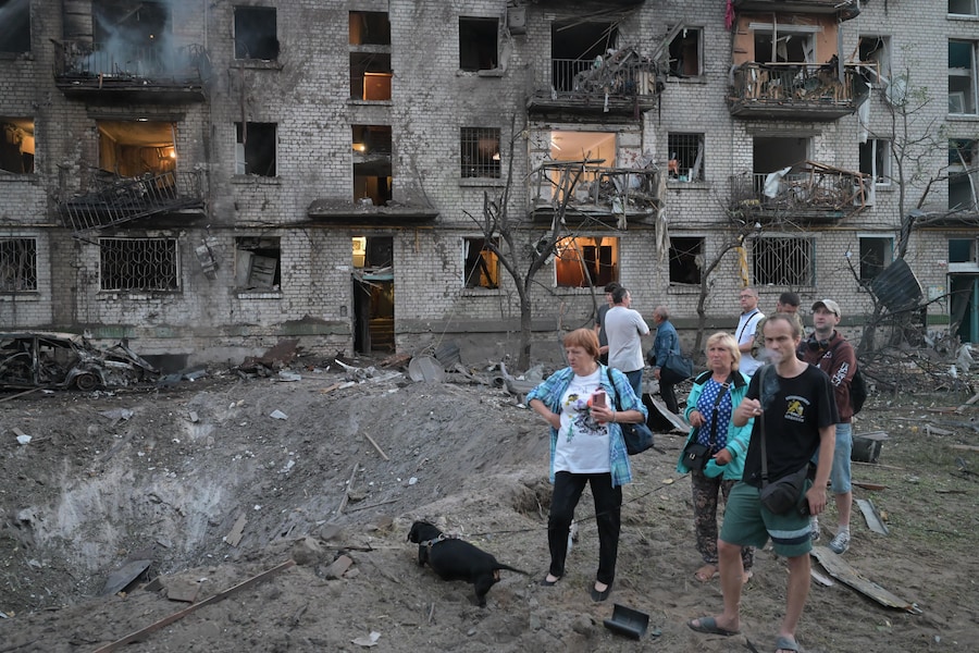 La gente osserva il luogo in cui un missile russo ha colpito un edificio residenziale a Kiev, in Ucraina. (APN)