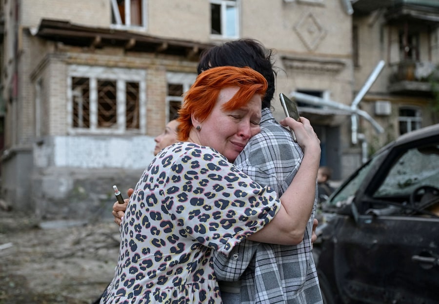 Una donna piange vicino a un condominio danneggiato durante un attacco russo con missili e droni a Kiev (REUTERS)