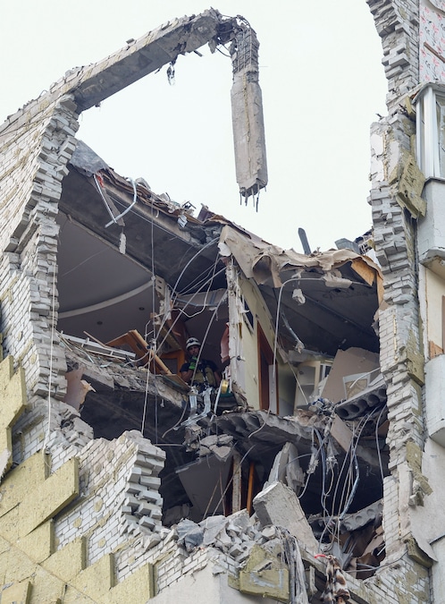 Un soccorritore è al lavoro all’ultimo piano di un condominio danneggiato durante gli attacchi notturni russi con missili e droni a Kiev (REUTERS)