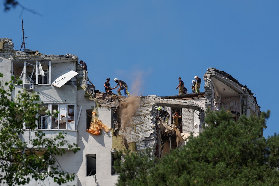 I soccorritori sono al lavoro sul tetto di un condominio danneggiato durante gli attacchi notturni russi con missili e droni a Kiev (REUTERS)