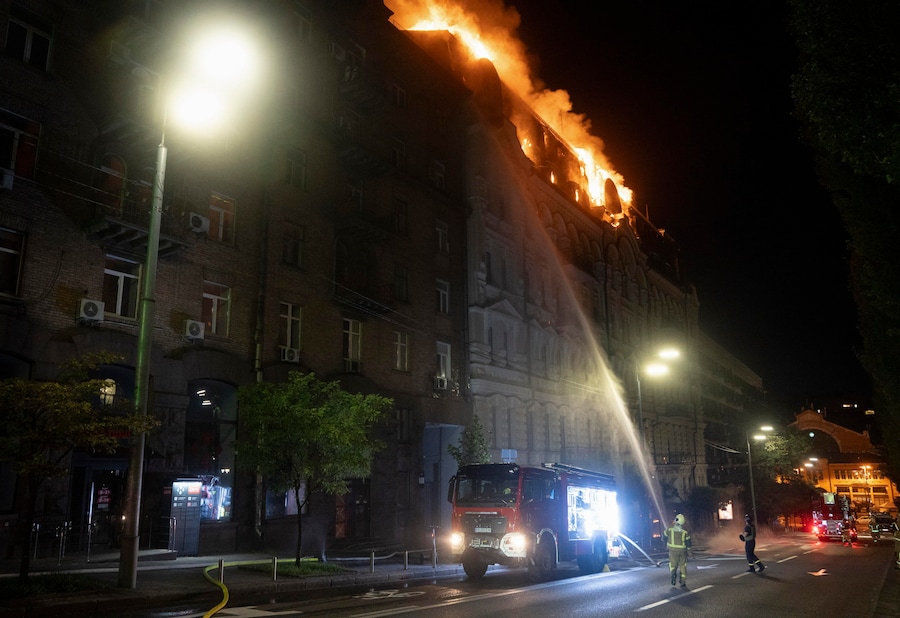 Vigili del fuoco ucraini operano sul luogo colpito da un drone russo – un edificio adibito a hotel – nel centro di Kiev (EPA)