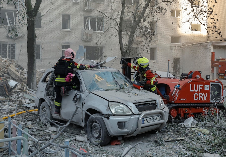 Soccorritori ucraini operano sul luogo colpito da un missile russo contro un edificio residenziale di nove piani a Kiev (EPA)