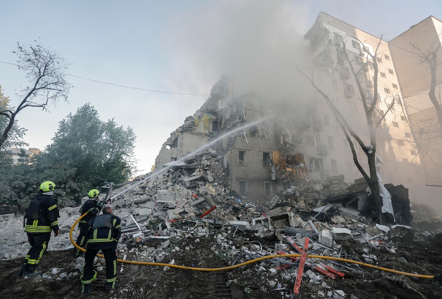 Soccorritori ucraini al lavoro sul luogo colpito da un missile russo – un edificio residenziale di nove piani – a Kiev (EPA)