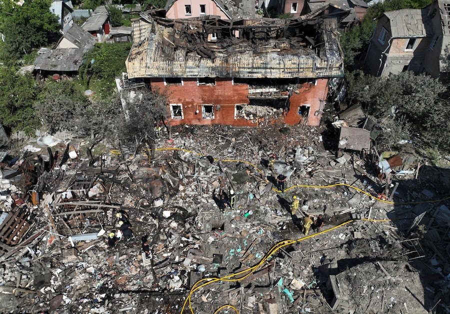 Una ripresa dall’alto mostra i soccorritori al lavoro presso un’abitazione privata danneggiata durante gli attacchi notturni russi con missili e droni a Kiev (REUTERS)