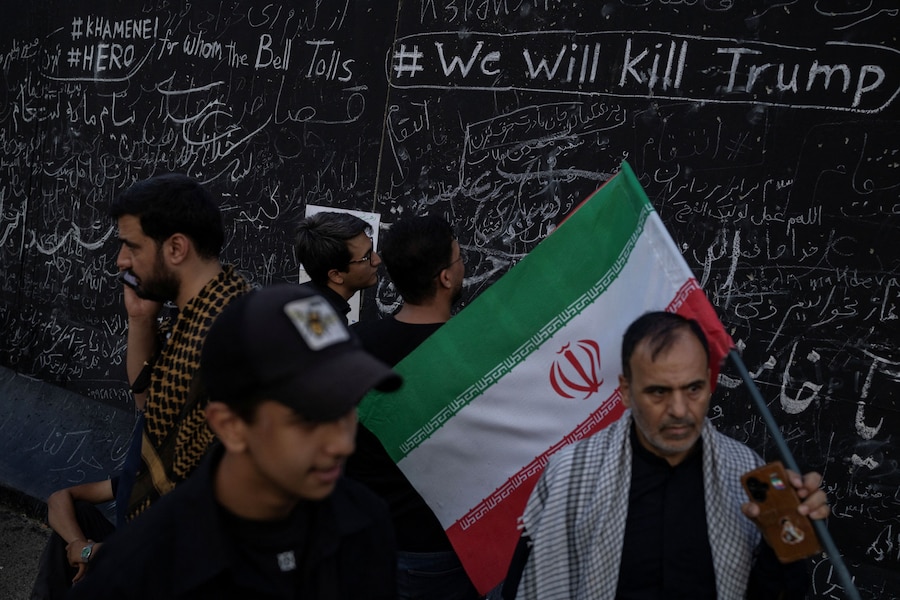 Alcune persone sono in piedi accanto a un muro su cui sono stati scritti slogan dai partecipanti al lutto, durante una cerimonia pubblica di addio per rendere omaggio al defunto Leader Supremo, l’Ayatollah Ali Khamenei, ucciso il 28 febbraio in seguito a attacchi aerei israeliani e statunitensi, presso la Grande Mosalla dell’Imam Khomeini, a Teheran, in Iran, il 4 luglio 2026. REUTERS/Alkis Konstantinidis (REUTERS)