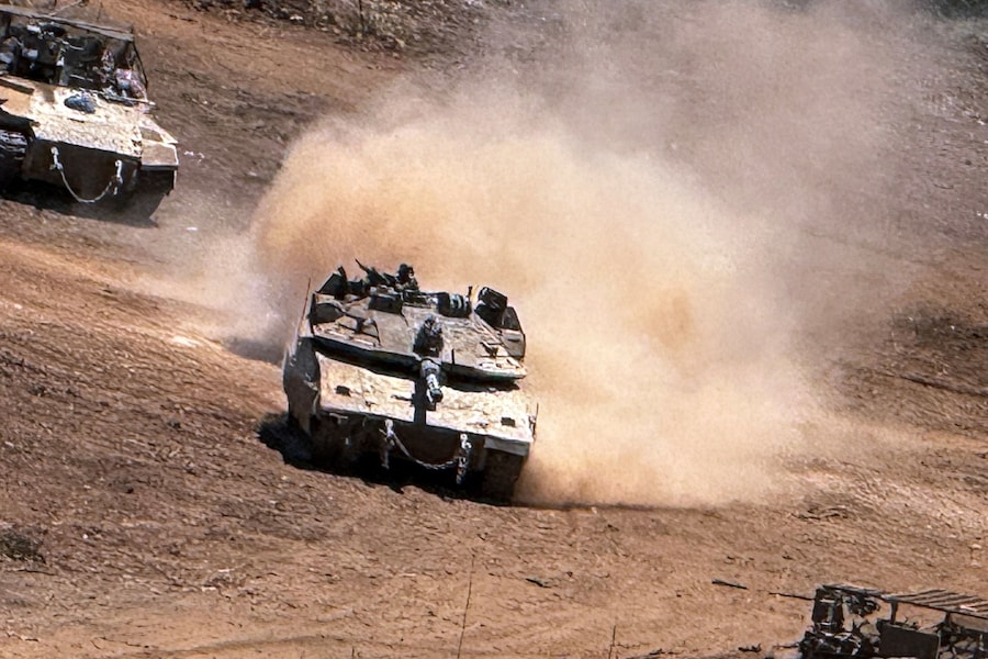 Un carro armato israeliano e un veicolo corazzato da trasporto truppe (APC) si muovono sul versante israeliano del confine tra Israele e Libano, dopo aver attraversato il confine per entrare in Israele. Foto scattata con un cellulare. REUTERS/Avi Ohayon (REUTERS)