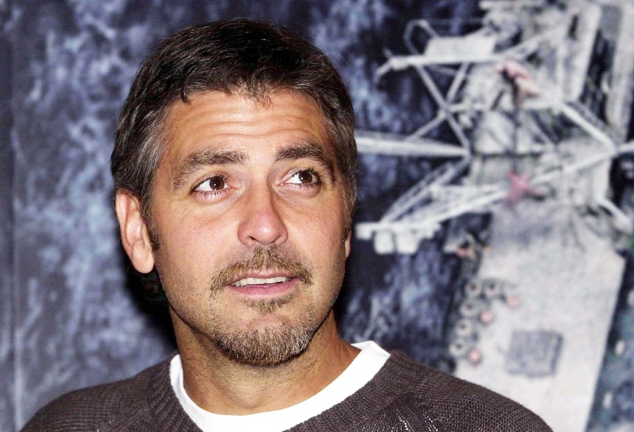 L'attore George Clooney in posa davanti a un manifesto del suo nuovo film *The Perfect Storm* a Londra, giovedì 20 luglio 2000. (FOTO ANSA / EPA PA/FIONA HANSON/FJH-hh / PAL)