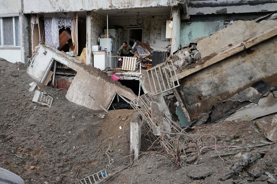 I residenti ripuliscono le macerie nel loro condominio danneggiato a seguito di un attacco missilistico russo a Kiev, in Ucraina, lunedì 6 luglio 2026. (AP Photo/Efrem Lukatsky/Associated Press/LaPresse/APN)