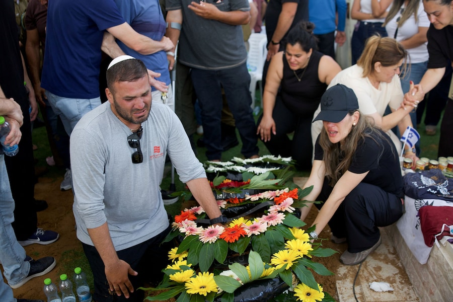 I partecipanti al funerale piangono davanti alla tomba del capitano David Hazutt, un soldato israeliano che, secondo l’esercito israeliano, è stato ucciso in uno scontro con un militante di Hezbollah nel Libano meridionale, durante le sue esequie ad Ashkelon, in Israele. REUTERS/Itai Ron (REUTERS)