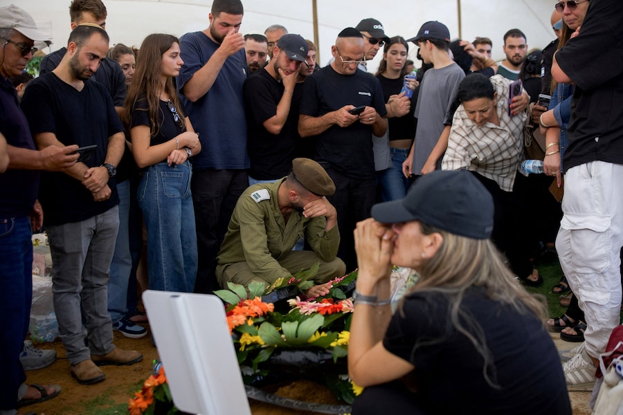 I partecipanti al funerale piangono davanti alla tomba del capitano David Hazutt, un soldato israeliano che, secondo l’esercito israeliano, è stato ucciso in uno scontro con un militante di Hezbollah nel Libano meridionale, durante le sue esequie ad Ashkelon, in Israele. REUTERS/Itai Ron (REUTERS)