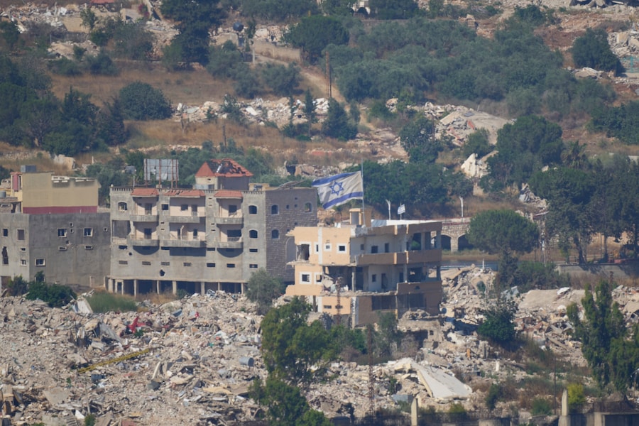 Una bandiera israeliana sventola su un edificio distrutto nel Libano meridionale, vista dal nord di Israele, (AP Photo/Ohad Zwigenberg) (APN)