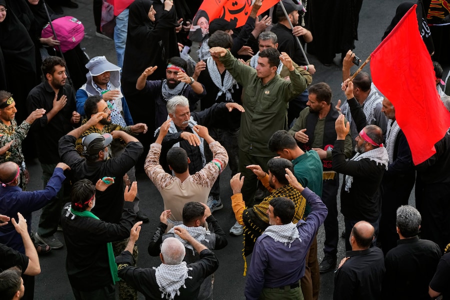I partecipanti al funerale intonano canti e compiono rituali funebri mentre si dirigono verso il corteo funebre. Teheran, in Iran. (APN)