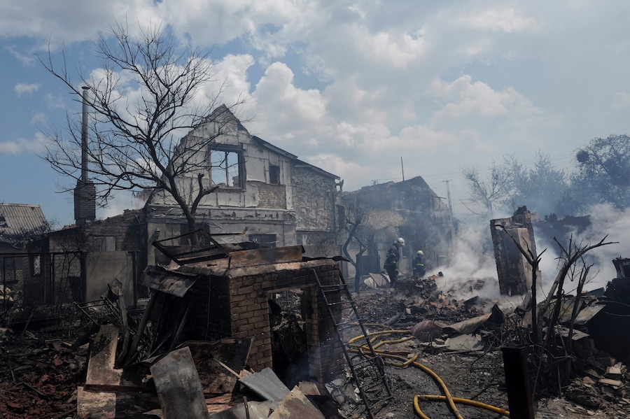 I vigili del fuoco intervengono dopo un attacco russo con missili e droni nella periferia di Kiev. (REUTERS)
