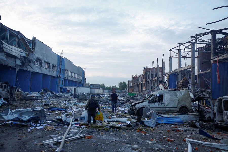 I dipendenti camminano tra le macerie del sito dei magazzini di generi alimentari e bevande colpiti da un attacco missilistico russo avvenuto durante la notte, nel contesto dell’offensiva russa contro l’Ucraina, a Kiev, Ucraina. (REUTERS)