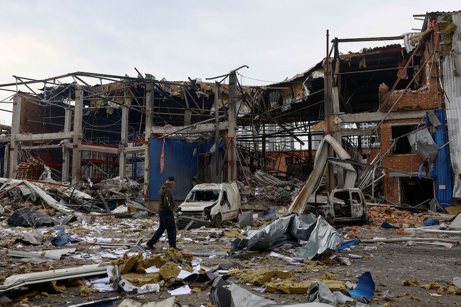 Un dipendente cammina tra le macerie nel luogo in cui si trovano i magazzini di generi alimentari e bevande colpiti da un attacco missilistico russo avvenuto durante la notte, nel contesto dell’offensiva russa contro l’Ucraina, a Kiev, Ucraina. (REUTERS)