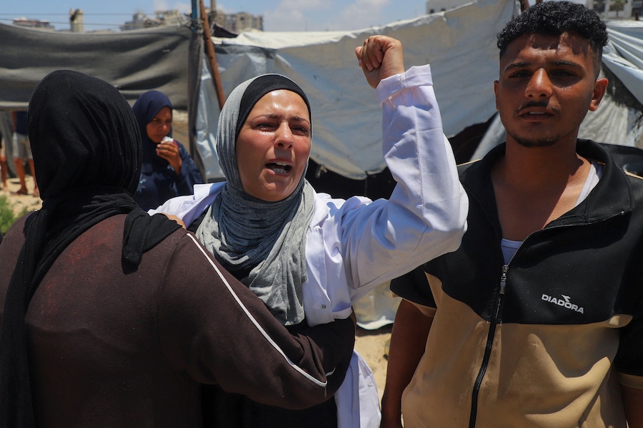 Una donna osserva mentre alcuni palestinesi ispezionano il luogo in cui un attacco israeliano ha colpito una tenda in un campo che ospita sfollati, nella città di Gaza, il 7 luglio 2026. REUTERS/Ebrahim Hajjaj (REUTERS)