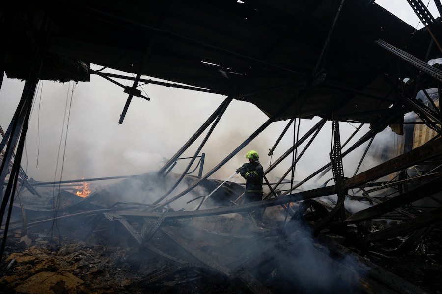 Un pompiere è al lavoro sul luogo in cui si trovano i magazzini di generi alimentari e bevande colpiti durante la notte da un attacco missilistico russo, nel contesto dell'offensiva russa contro l'Ucraina, a Kiev. (REUTERS/Valentyn Ogirenko)