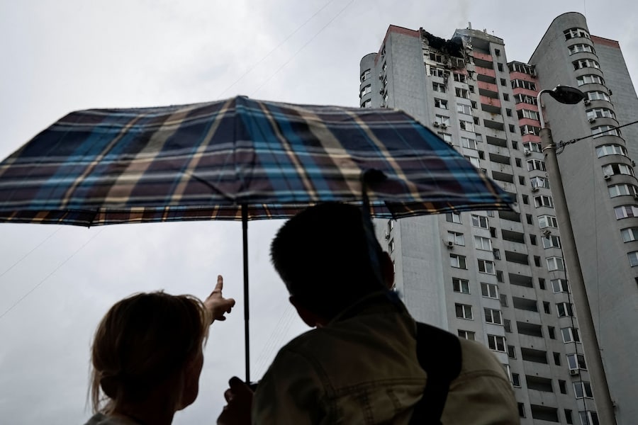 Alcuni residenti si trovano nei pressi di un condominio colpito da un attacco con droni russi, a Kiev, Ucraina. (REUTERS/Yan Dobronosov)