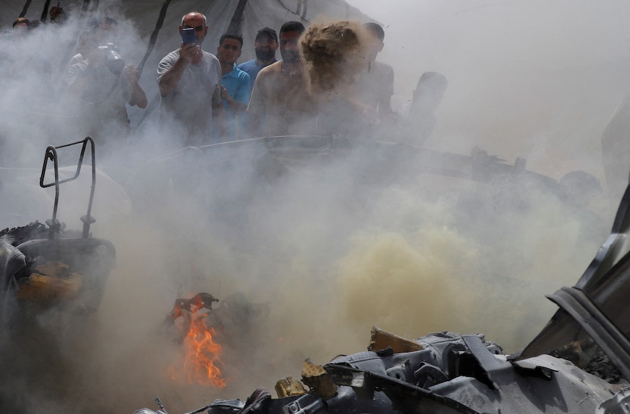 I palestinesi usano la sabbia per spegnere un incendio in seguito a un attacco israeliano contro un veicolo nella città di Gaza, il 9 luglio 2026. REUTERS/Ebrahim Hajjaj (REUTERS)