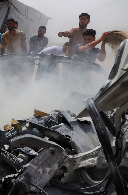 I palestinesi usano la sabbia per spegnere un incendio in seguito a un attacco israeliano contro un veicolo nella città di Gaza, il 9 luglio 2026. REUTERS/Ebrahim Hajjaj (REUTERS)