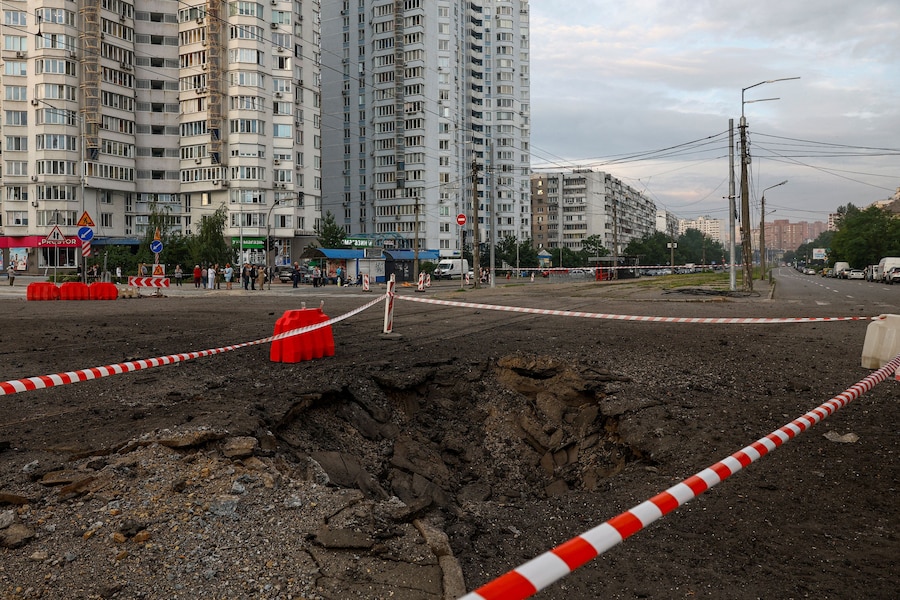 Gli abitanti si radunano accanto a un cratere formatosi in seguito agli attacchi missilistici russi, a Kiev, Ucraina, l'11 luglio 2026. (REUTERS/Valentyn Ogirenko)