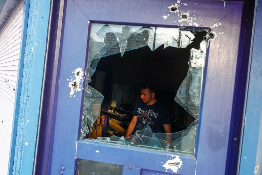 Un residente rimuove le macerie all'interno del suo negozio di barbiere, danneggiato durante gli attacchi missilistici russi nel contesto dell'offensiva russa contro l'Ucraina, a Kiev, Ucraina, l'11 luglio 2026. (REUTERS/Valentyn Ogirenko)