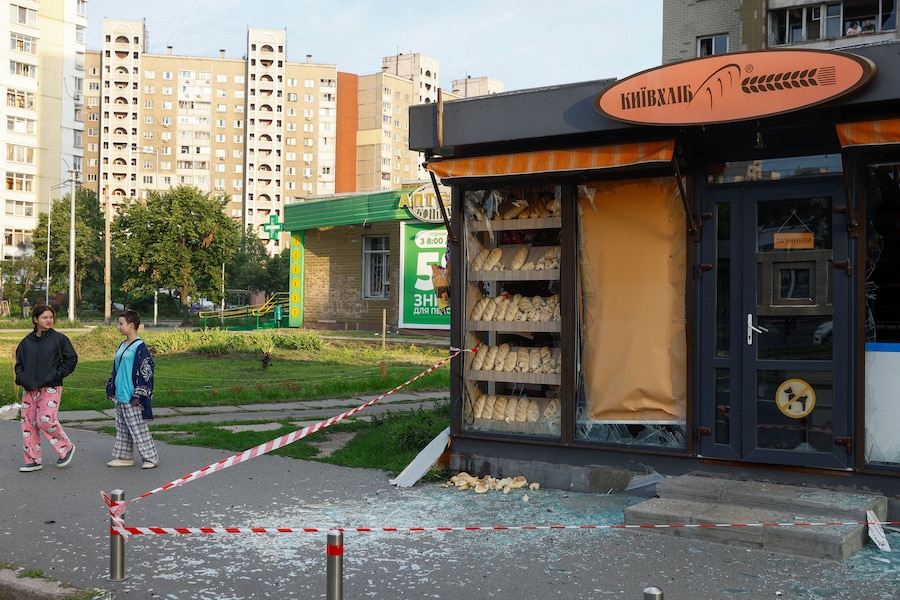 Dei ragazzi camminano accanto a una panetteria danneggiata durante gli attacchi missilistici russi, a Kiev, Ucraina, l'11 luglio 2026. (REUTERS/Valentyn Ogirenko)