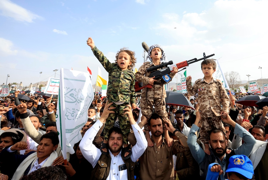 Sostenitori degli Houthi e i loro figli gridano slogan durante una manifestazione di solidarietà con il popolo iraniano. (EPA)