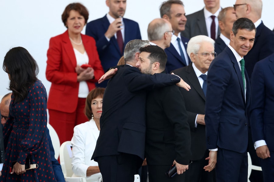 Il primo ministro britannico Keir Starmer saluta il presidente ucraino Volodymyr Zelenskiy prima dell'inizio della parata militare annuale del Giorno della Bastiglia in Place de la Concorde a Parigi, in Francia, il 14 luglio 2026. (REUTERS/Tom Nicholson)