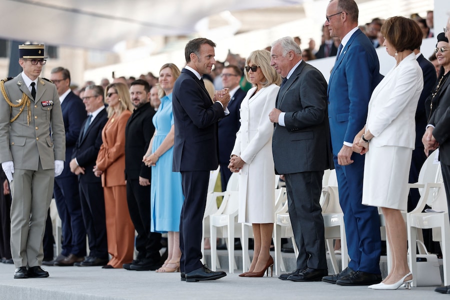 Il presidente francese Emmanuel Macron saluta il cancelliere tedesco Friedrich Merz e gli ospiti provenienti dai paesi della “Coalizione dei volenterosi”, sotto lo sguardo del presidente ucraino Volodymyr Zelenskiy, durante la parata militare annuale del Giorno della Bastiglia in Place de la Concorde a Parigi, in Francia, il 14 luglio 2026. (REUTERS/Benoit Tessier/Pool)