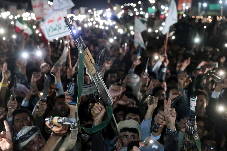 I sostenitori degli Houthi brandiscono le armi durante una manifestazione contro i raid aerei sull'aeroporto internazionale di Sanaa. (REUTERS)